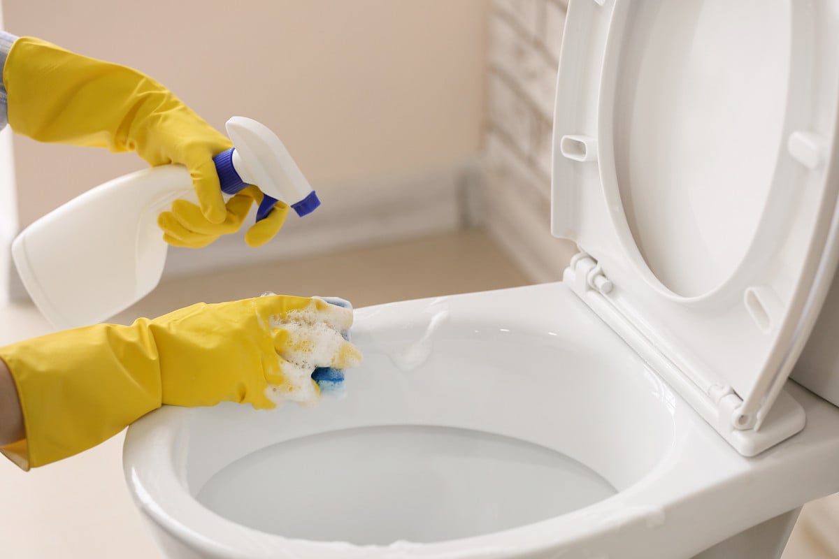 iemand maakt het toilet schoon