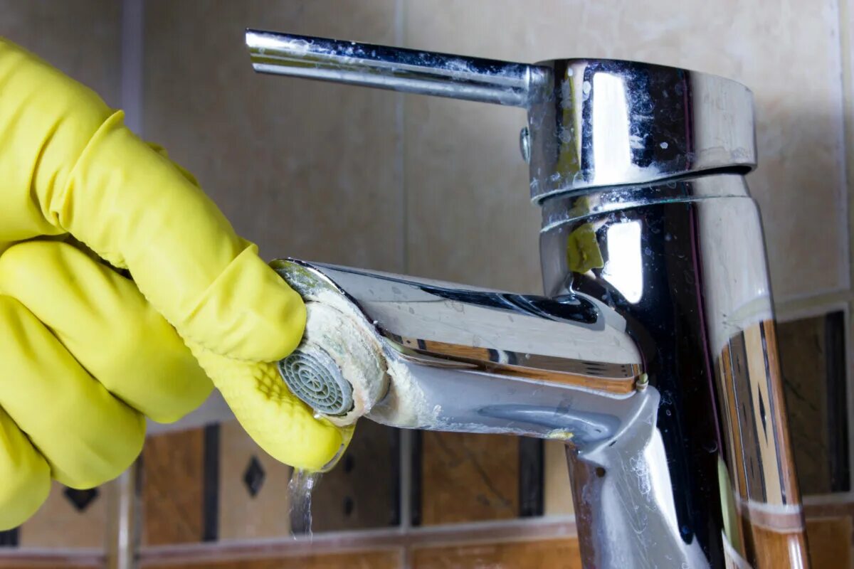 Een man maakt de kraan schoon