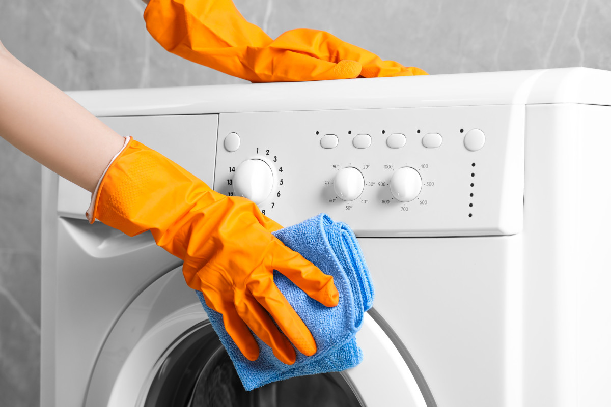 iemand maakt de wasmachine schoon