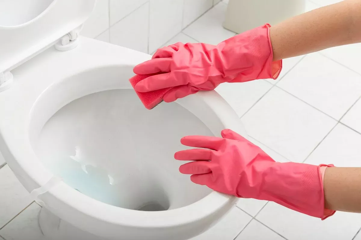 iemand maakt het toilet schoon